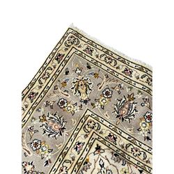 Persian Kashan ivory ground carpet, floral central medallion surrounded by trailing leafy branches and palmettes, floral pattern spandrels and matching border, within guard stripes