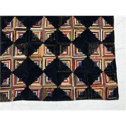 19th century log cabin pattern bedspread, worked with polychrome silks upon dark navy velvet ground, with orange geometric patterned lining to reverse, 140cm x 106cm