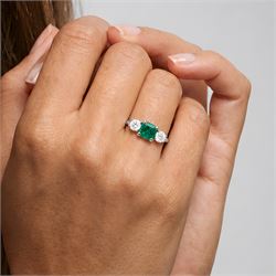 18ct white gold emerald and diamond three stone ring, single modified square cut emerald of approx 0.65 carat, with a round brilliant cut diamond set either side, hallmarked, total diamond weight approx 0.35 carat