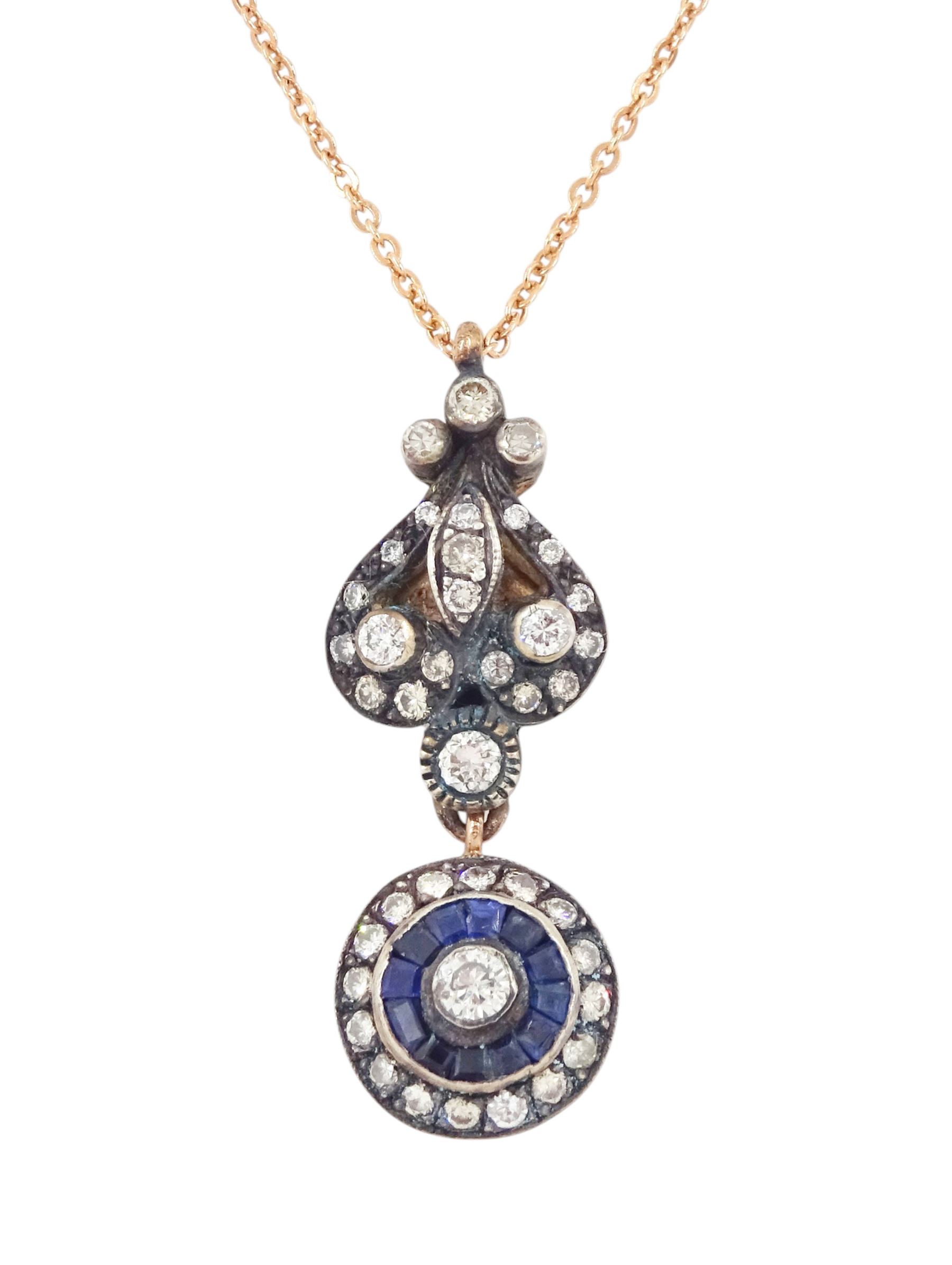 Gold and silver sapphire and diamond pendant, single round brilliant cut diamond, surrounded by calibre cut sapphires and round brilliant cut diamonds, suspending from a fancy pendant set with further diamonds, on a rose gold plated silver chain necklace, total diamond weight approx 0.60 carat