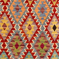 Afghan Chobi flatweave kilim, with a repeating stepped diamond medallion design in ivory, green, rust, teal, purple, indigo, and framed by chevron and geometric borders