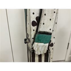 Folk art circus clown cabinet, the the two hinged doors with bow tie decoration opening to reveal fitted shelved interior, the body painted with polka dots and spades, H121cm