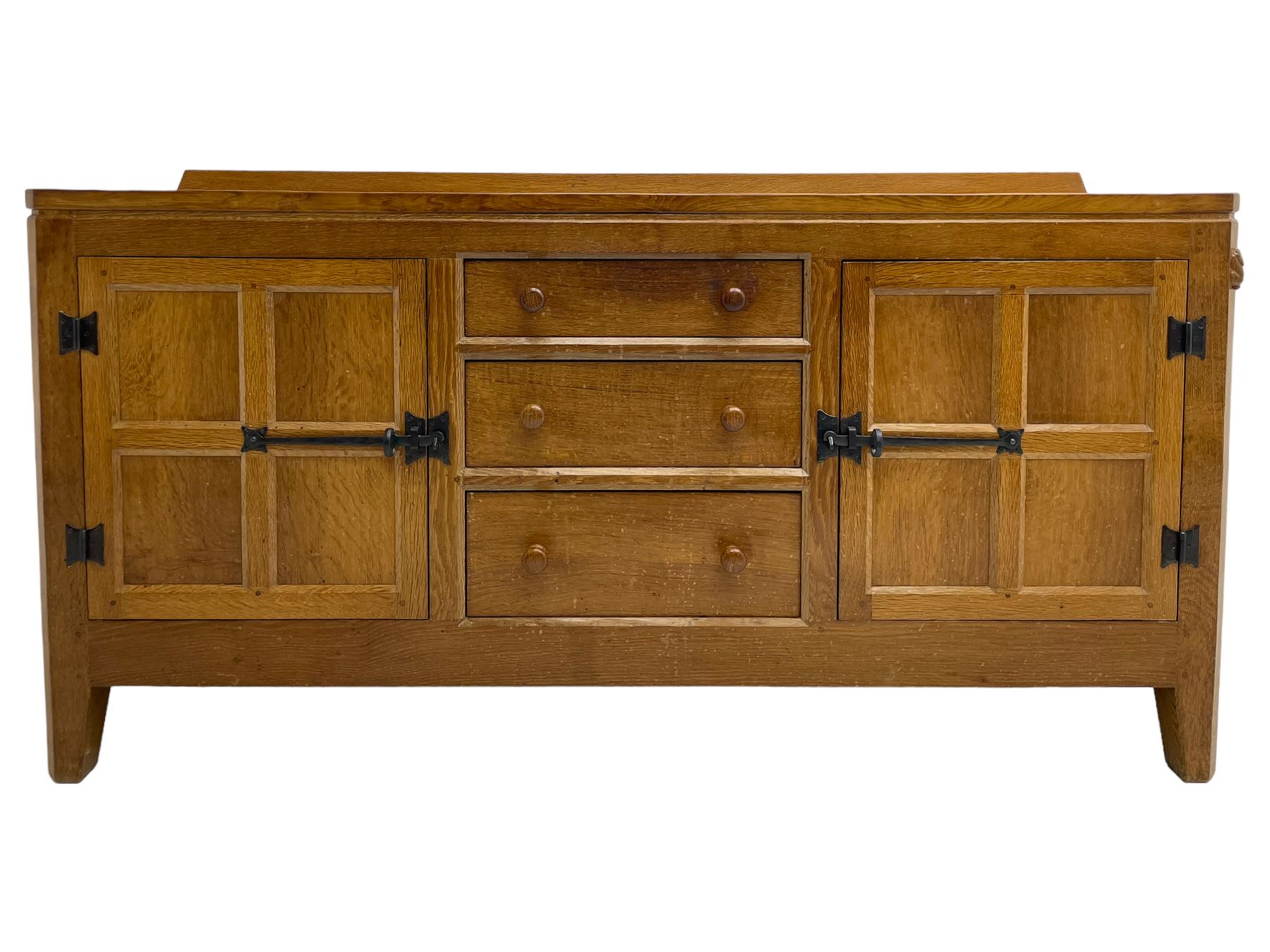 Rabbitman - adzed oak sideboard, fitted with three central drawer and two flanking cupboards, panelled doors with iron latches and hinges, carved with rabbit signature, by Peter Heap, Wetwang