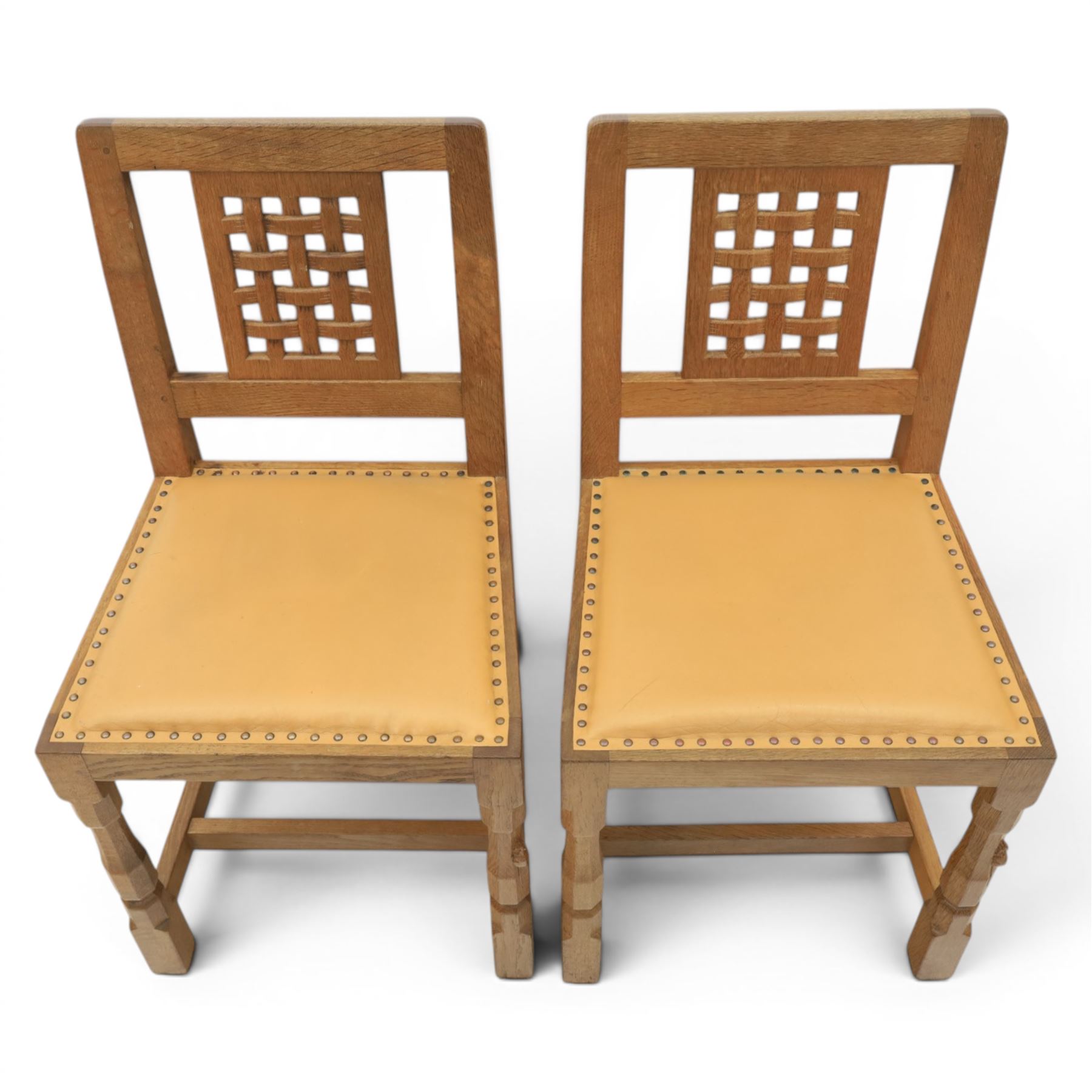 Mouseman - set of four oak lattice back chairs with tan seat with brass studded trim, with carved mouse signature, by the workshop of Robert Thompson of Kilburn