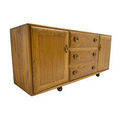 Ercol - mid-20th century blonde elm 'Windsor' sideboard, fitted with three drawers flanked two cupboards, on castors
