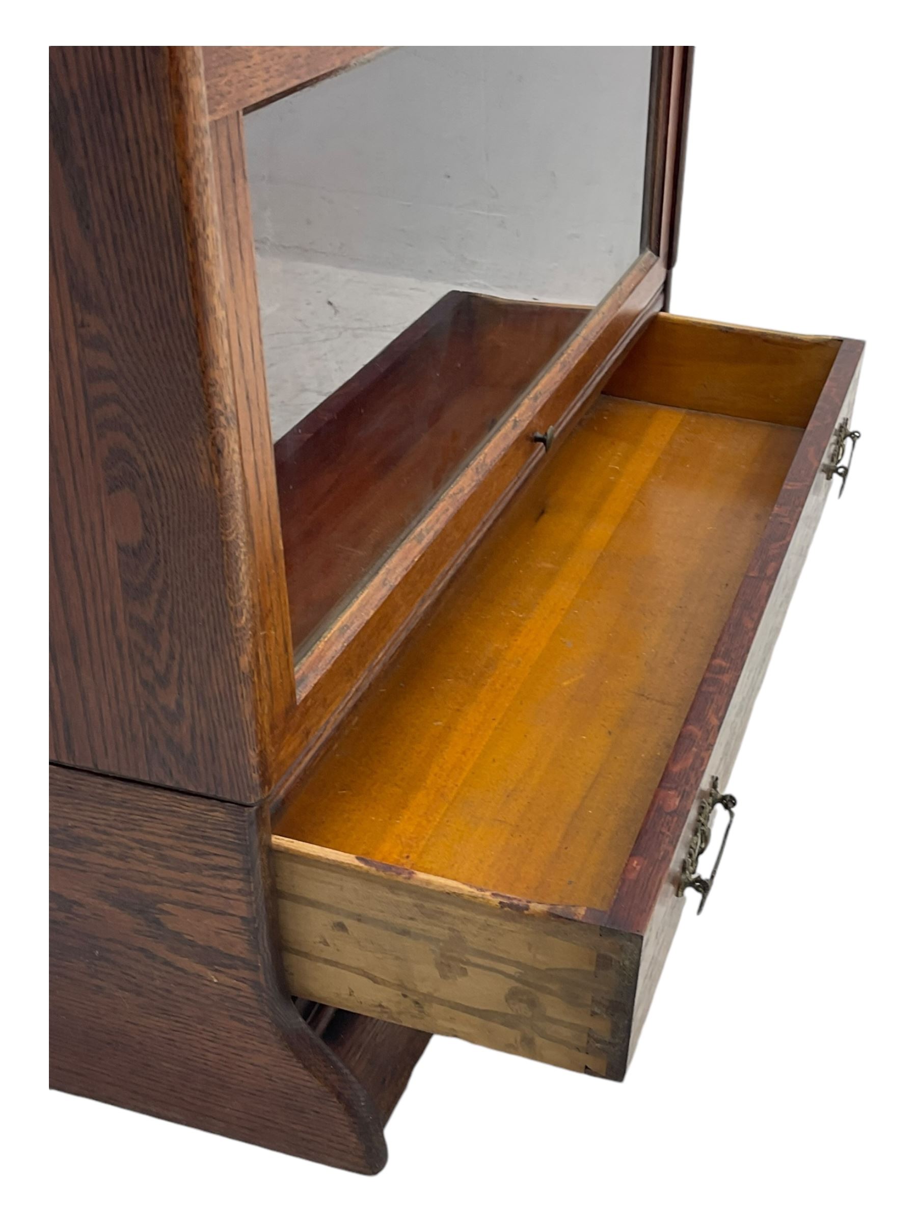 Early 20th century oak stacking library bookcase, four sections enclosed by hinged and sliding glazed doors, fitted with single drawer 