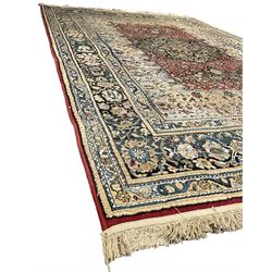 Persian design rug, rectangular crimson ground field with medallion, surrounded by trailing foliate branches, within wide border bands decorated with stylised floral motifs 