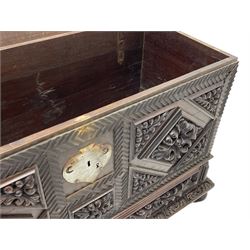Early 20th century carved hardwood kist or mule chest of small proportions, moulded rectangular hinged lid over foliage carved geometric lozenge panels, the frame carved with chevron banding, fitted with two drawers, the drawer fronts carved with extending leaf motifs over a foliage carved lower moulding, on turned feet