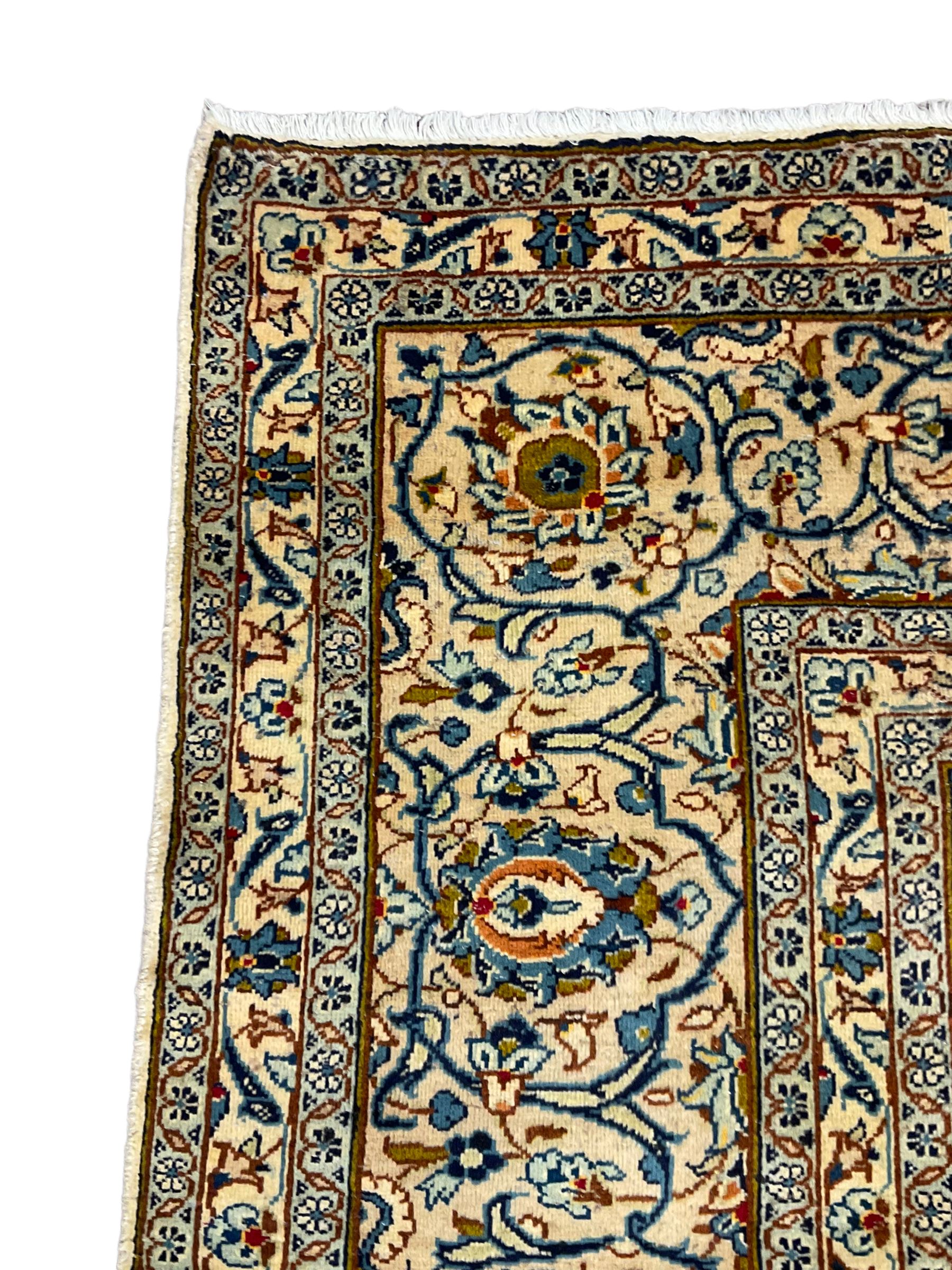 Persian Kashan golden ivory ground carpet, the central medallion surrounded by a field of interlacing branch and stylised plant motifs, the guarded border with scrolling design decorated with flower heads 