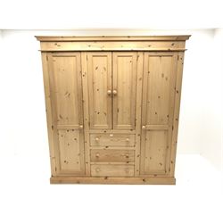 Solid pine combination wardrobe, two long doors flanking two short doors and three drawers, plinth base