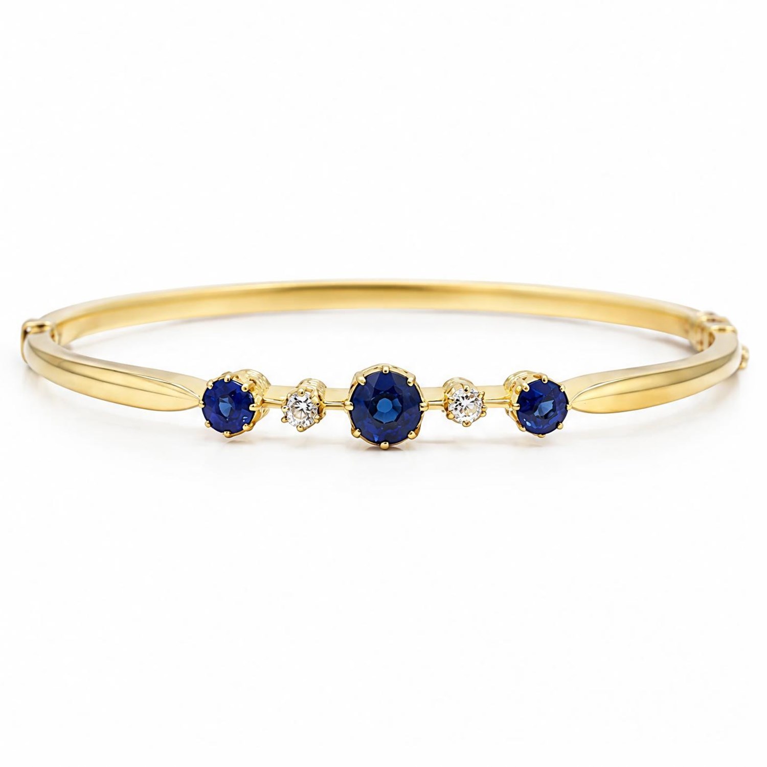 Early 20th century 18ct gold sapphire and diamond hinged bangle, the front set with three round cut sapphires and spaced by two old cut diamonds, total sapphire weight approx 1.15 carat