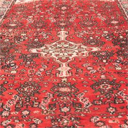 Persian crimson ground runner rug, the field decorated with repeating Herati motifs around an ivory pendant medallion, stepped ivory spandrels with stylised floral ornament, enclosed by a dark ground star border and narrow guard stripes