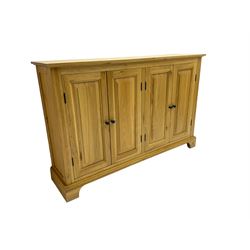 Light oak sideboard, fitted with four panelled cupboards 