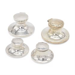 Four early 20th century silver mounted capstan inkwells, all of typical circular form with hinged covers, all hallmarked 