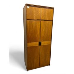 William Lawrence - mid-20th century teak double wardrobe, upper storage section over twin doors featuring recessed handles and contrasting horizontal panel, enclosing a hanging rail compartment, on plinth base with concealed castors