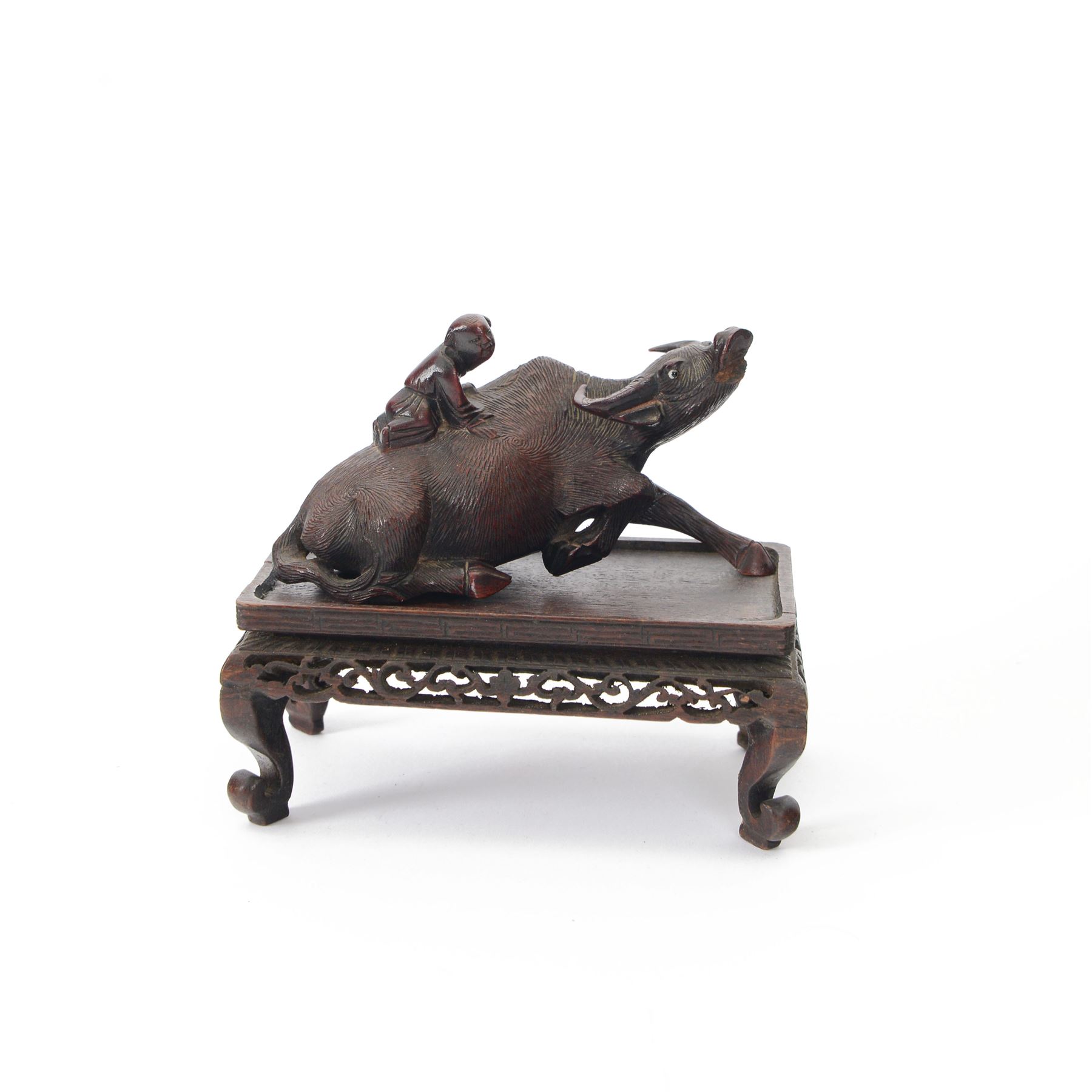 Chinese carved hardwood model of an ox or water buffalo, with attendant upon back, upon a carved openwork stand with cabriole lets, model H6.5cm L13cm