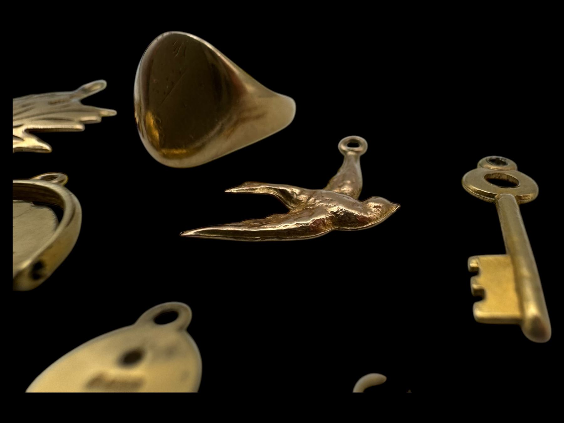 9ct gold charms, including crossed swords, signet ring, horseshoe and leaf, and a 14ct gold fireplace charm