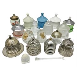 Collection of glass beehive honey pots, to include a blue slag example, milk glass, pink, green, etc together with four white metal examples (16) 