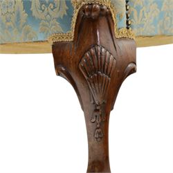 Georgian design carved mahogany framed wingback armchair, high wingback over sprung seat and loose cushion with rolled arms, upholstered in cyan ground gilt foliate damask fabric, on shell-carved cabriole supports with pad feet