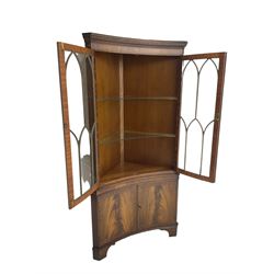 Bevan Funnell Reprodux - mahogany concave corner display cabinet, the moulded and dentil cornice over two astragal glazed doors, double cupboard below enclosed by figured doors, on bracket feet