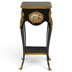 Early 20th century French ebonised sewing or work table, rectangular hinged top with foliate moulded gilt metal edge, enclosing upholstered interior, over a central Sevres style porcelain plaque depicting a courting scene, raised on cabriole supports with gilt metal carotuche and acanthus knee mounts, united by undertier with brass gallery terminating to gilt metal scroll feet