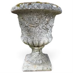 Set of four weathered composite stone urns of campana form, the everted leaf-moulded rolled rim over a body decorated with scrolling fruiting grapevines in relief, over a gadrooned underbelly and waisted socle, lobed collar on square base