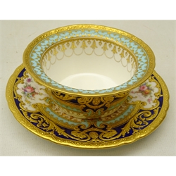  Royal Crown Derby ramekin and saucer from the Judge Elbert Henry Gary service, circa 1910, hand painted by Albert Gregory, signed, with baskets of flowers in cartouche shaped panels on cobalt blue and turquoise ground with raised gilded border incorporating an oval medallion with the initial 'G' by George Darlington, signed, printed backstamp in gilt with Royal Warrant and Tiffany & Co retailer's mark, saucer D12.5cm ramekin D9.5cm. Provenance Property of Bob Heath, Brandesburton Formerly of Ravenfield Hall Farm near Rotherham  
