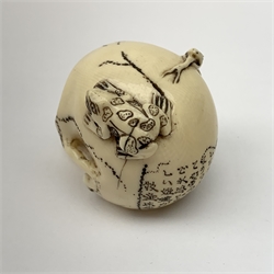 Japanese Meiji carved ivory netsuke, modelled as a skull, the top carved with two toads, and script and signature to reverse, L5cm, H4cm   