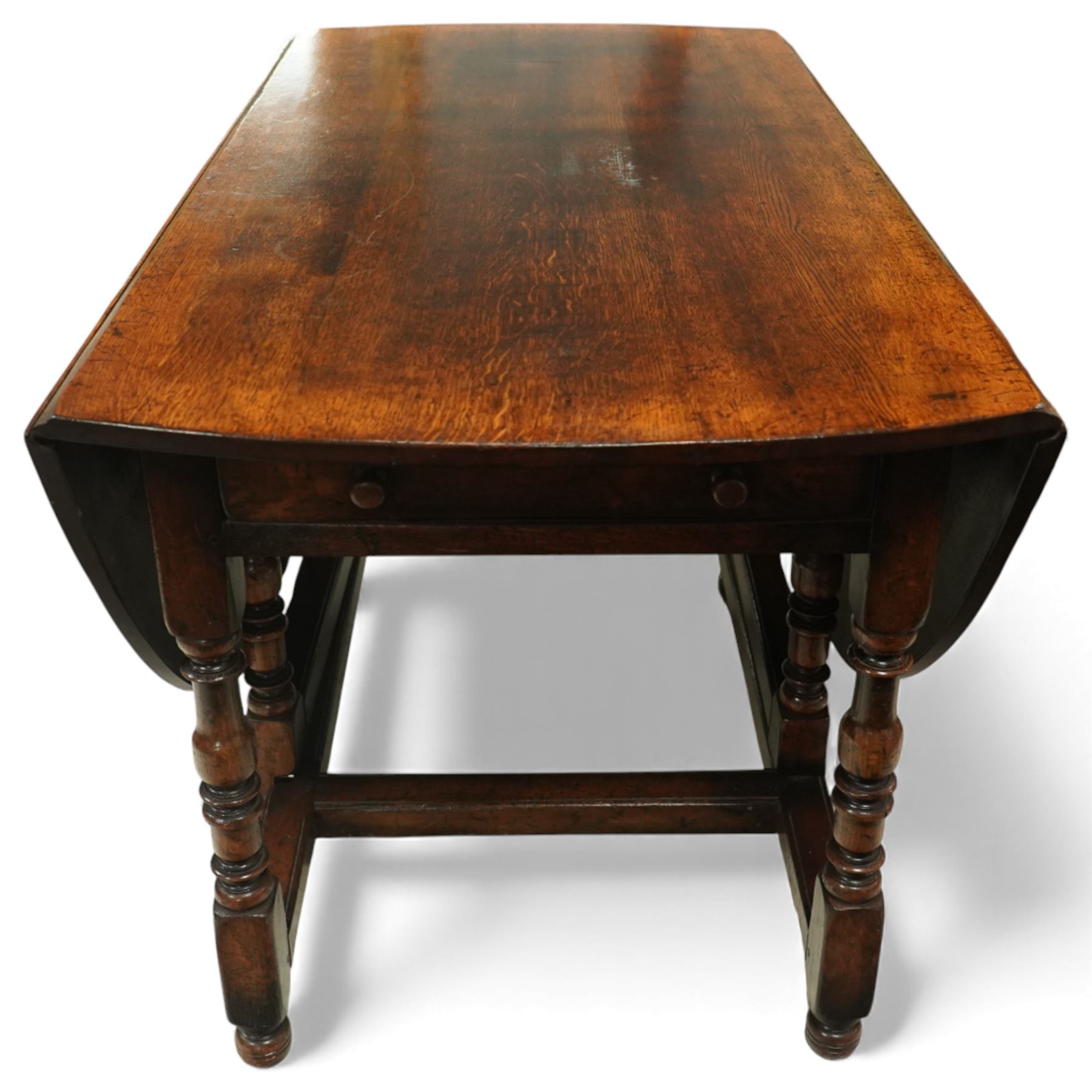 Large 18th century design oak drop-leaf dining table, oval top with twin hinged drop leaves, drawers to either end, raised on turned supports united by an H-stretcher base