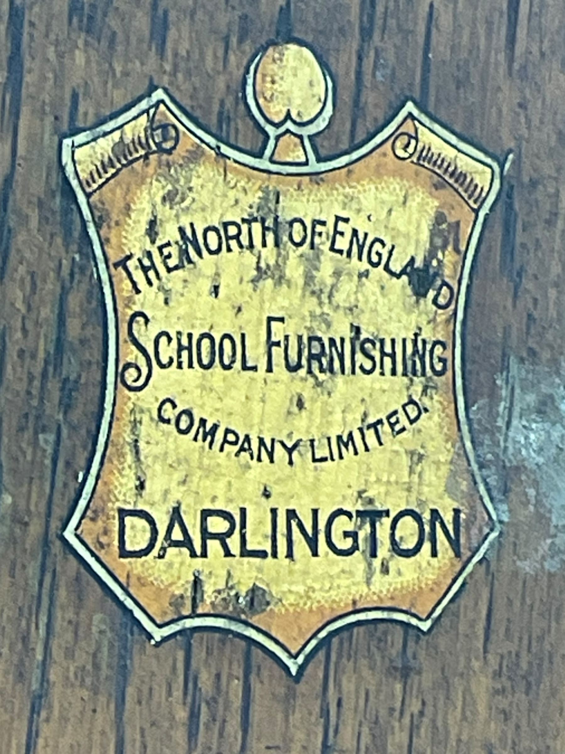 The North of England School Furnishing Company Limited Darlington - early 20th century oak school cupboard, projecting moulded cornice over two panelled doors, fitted with shelves, on chamfered plinth base 
