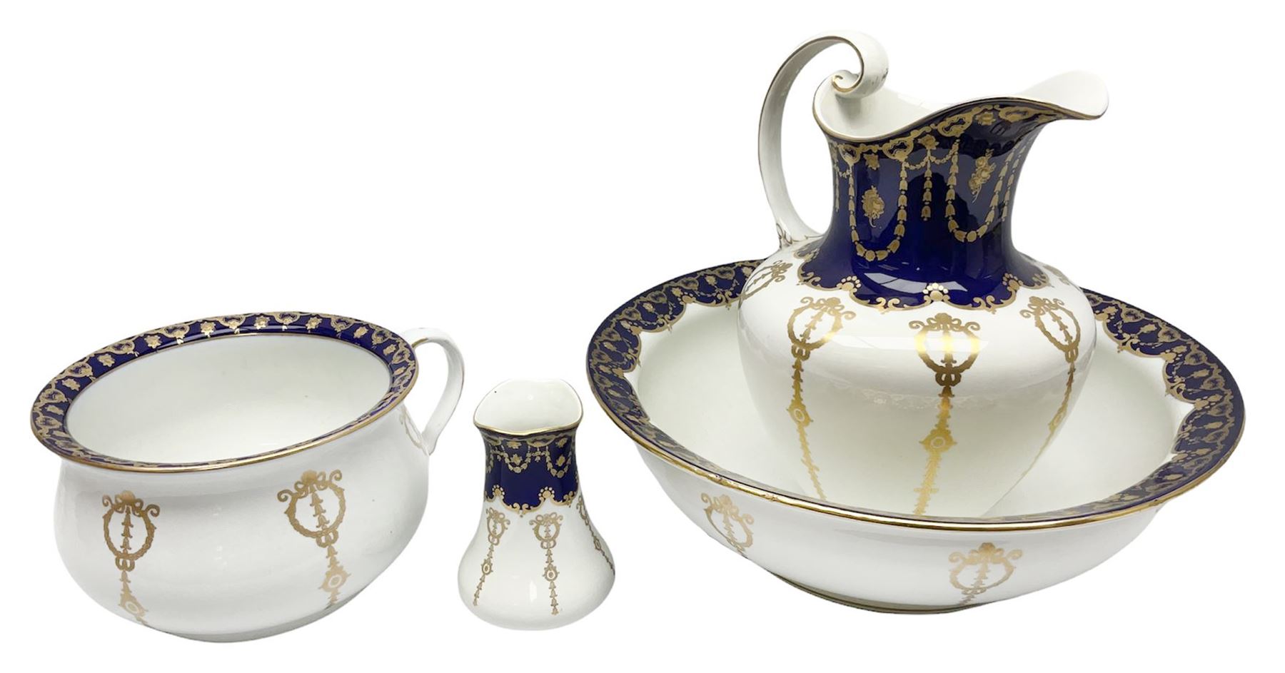 Early 20th century Bishop and Stonier four piece toilet set, comprising washbowl, wash jug, toothbrush pot, and chamber pot, each  decorated with deep blue band and husk swags and festoons in gilt, with printed Caduceus Bisto marks beneath and printed retailers mark 'Manufactured for Harrods Limited London', wash bowl D43cm, wash jug H31.5cm