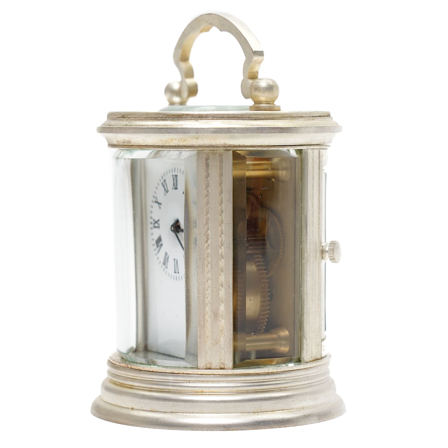 20th century-Silver plated 8-day timepiece carriage clock in an oval case, enamel dial with Roman numerals, minute track and steel moon hands, with an oval viewing class to the lever platform escapement. With key.