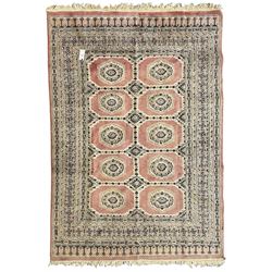 Persian design pale pink ground rug, the field divided into panels and decorated with Gul motifs, wide multi-band border with geometric patterns 