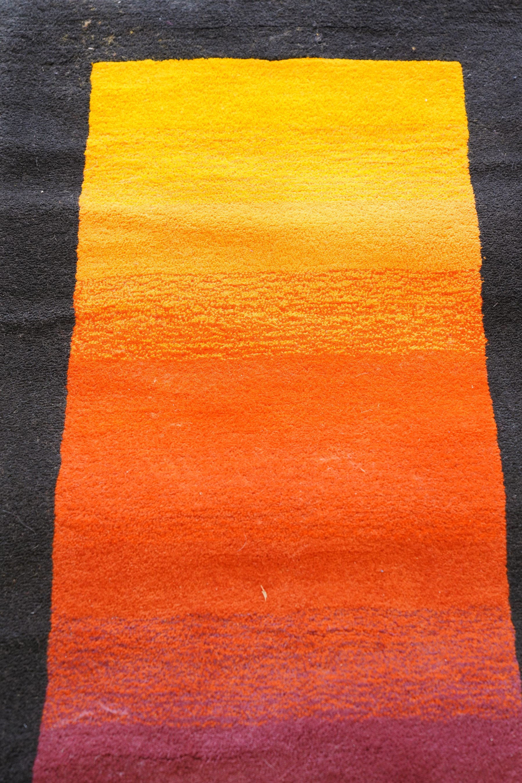 Contemporary wool runner rug, the field in a vibrant vibrant sunset-to-purple gradient with a wide dark indigo guard band