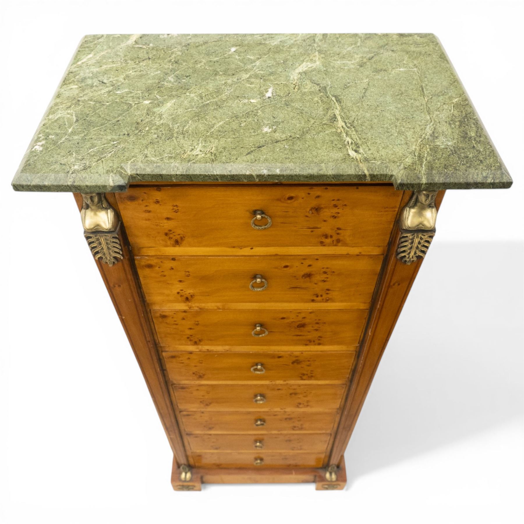 Neoclassical marble and inlaid figured maple wood tall chest, green marble inverted-breakfront top over eight long drawers, flanked by square tapering pilasters with gilt metal female bust and anthemion leaf capitals and brass feet terminals, the skirted base with applied Medusa gilt metal mounts, on compressed bun feet