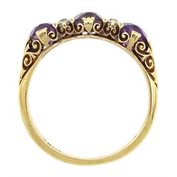 Early 20th century gold three stone oval amethyst and four stone old cut diamond ring with scroll design shoulders, stamped 18ct