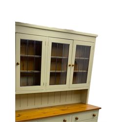 Traditional pine dresser, raised display cabinet enclosed by four lead glazed doors, polished rectangular top over three drawers and three panelled double cupboards