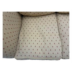 20th century Knole design two seat sofa, high back and double drop-arm joined by mahogany finials and ties, upholstered in camel ground fabric with red lozenge design, on turned supports with brass castors