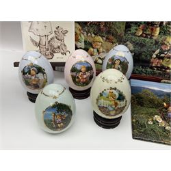 Two ceramic Hummel postcards by Goebel, both displayed on wooden easels, together nine Hummel eggs, set of four Hummel School Days plates, on wooden hanging rack, Goebel Collectors Club Member plaque etc