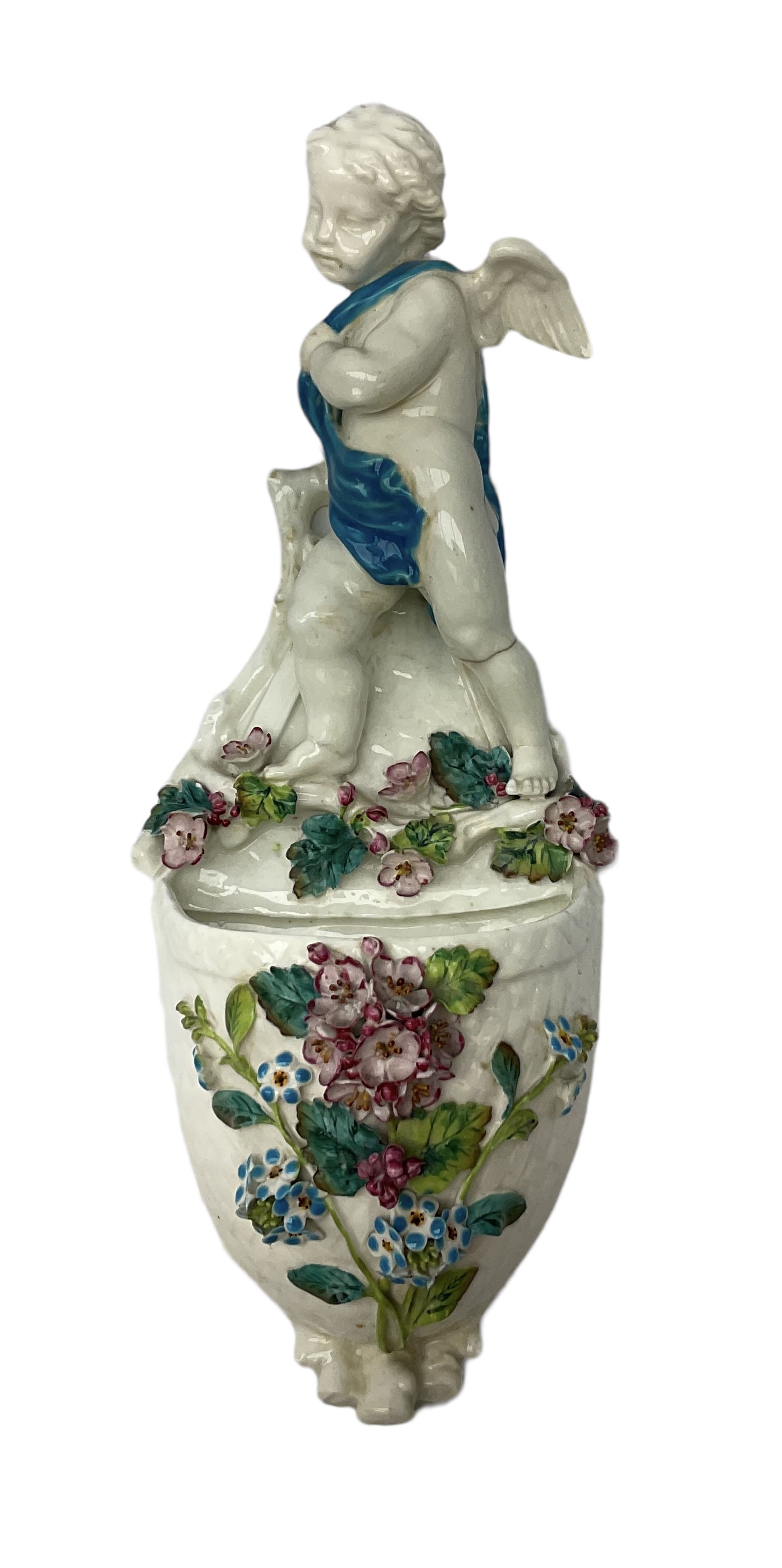 Victorian wall pocket by Moore Brothers retailed by T.Goode modelled as a semi nude white glaze cherub with turquoise ribbon, with encrusted floral decoration, the reverse stamped ‘T.Goode & Co.’, H32cm