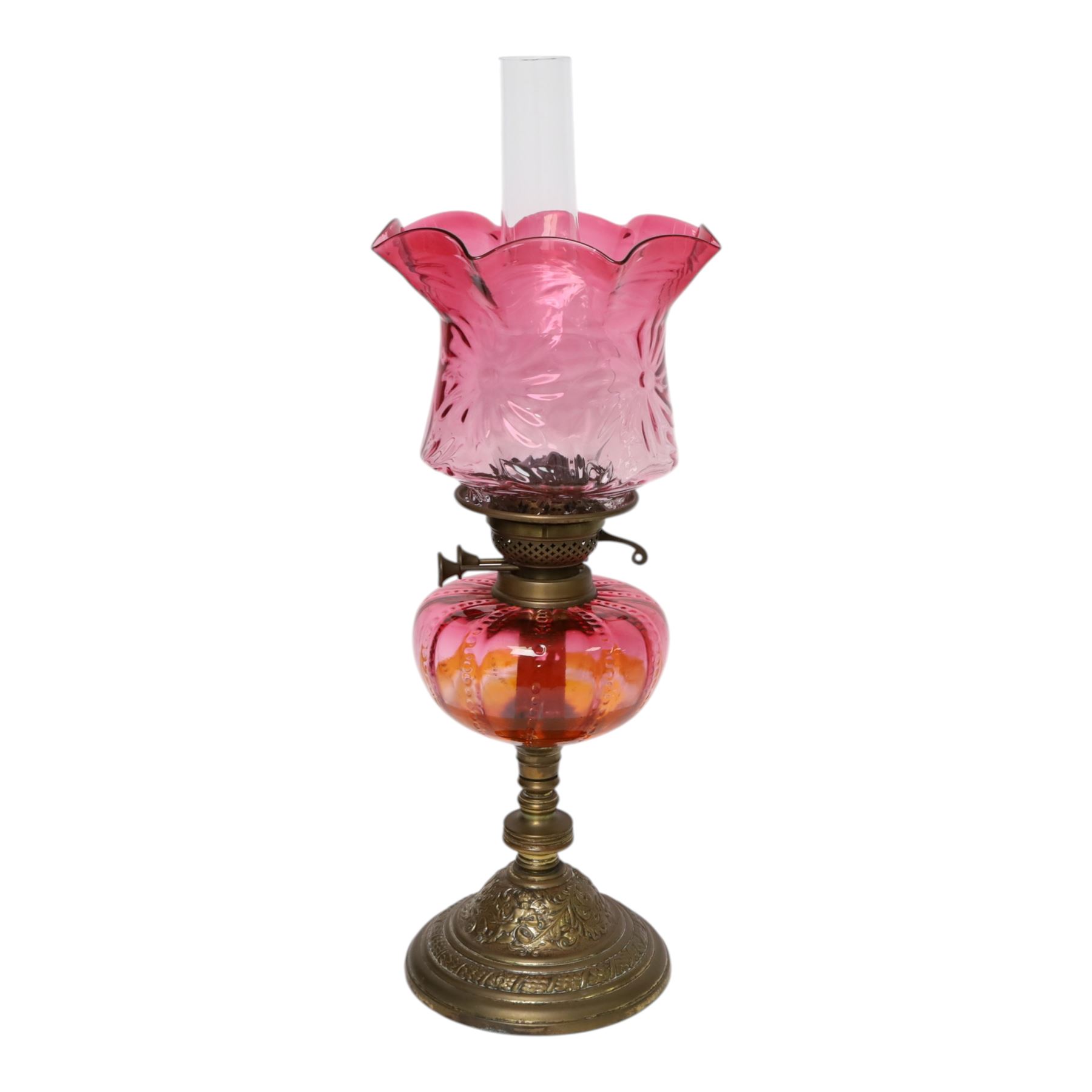 Victorian oil lamp, the brass base supporting cranberry glass reservoir, with clear glass chimney and cranberry shade with fluted rim, overall H59cm
