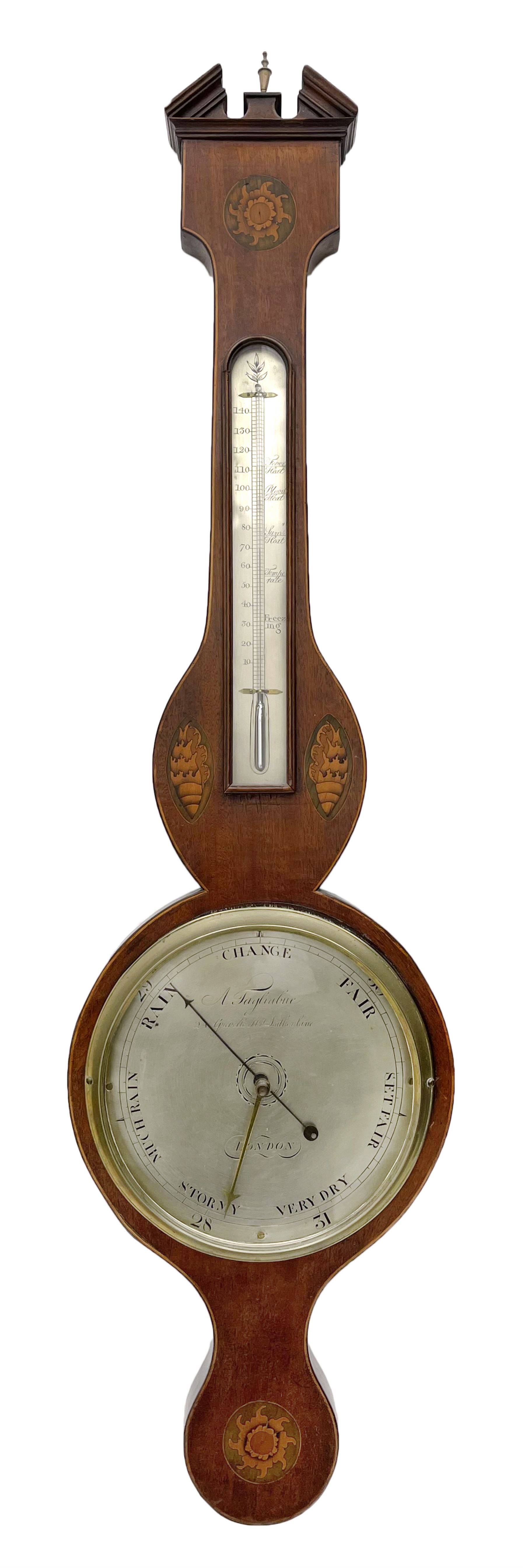 Early 19th century William IV mercury wheel barometer with a rosette inlaid broken pediment and correspondingly inlaid round base, mahogany veneered case with inlaid oval conch shell paterae and satinwood stringing to the edge, with an arched thermometer box and spirit thermometer measuring degrees Fahrenheit from 20 to 120, eight-inch silvered register reading barometric pressure in inches from 28  to 31, with predictions in Roman upper and lower case and script, dial inscribed “A Tagliabue,24 Grenville Street, Luther Lane, London”, with a steel indicating hand, brass recording hand and cast brass bezel.