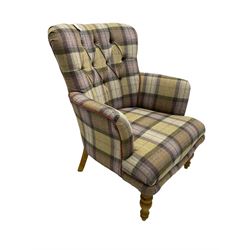 Traditional shaped armchair, upholstered in deep buttoned purple tartan fabric with red piping, raised on turned and tapering stained beech supports