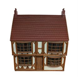 Two storey wooden dolls house with sliding panels, with a small collection of dolls house furniture, H57cm, W48cm