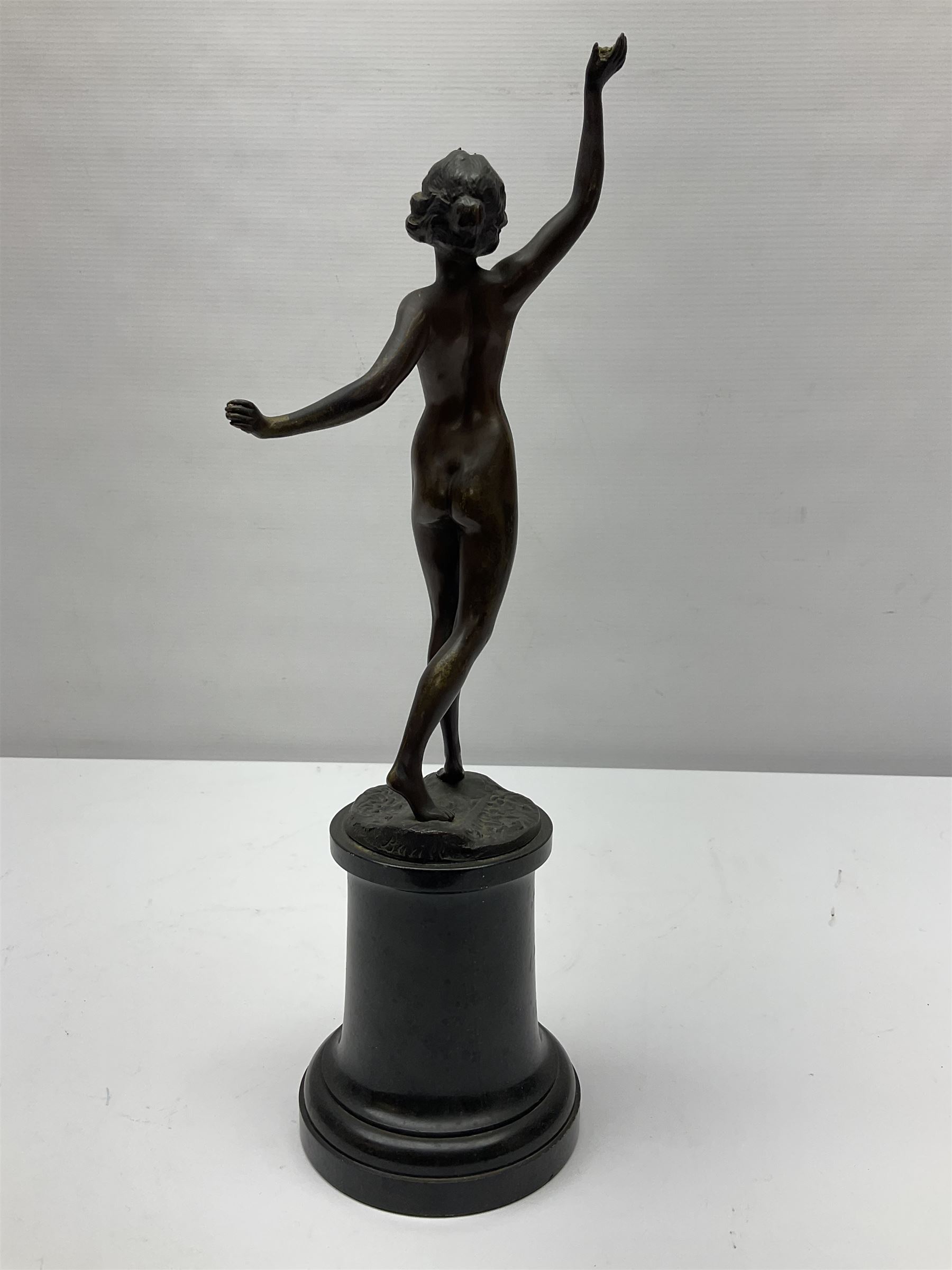 Bronze figure modelled as a nude woman with one arm raised a crescent moon upon her forehead, raised upon a circular stepped plinth, H36cm