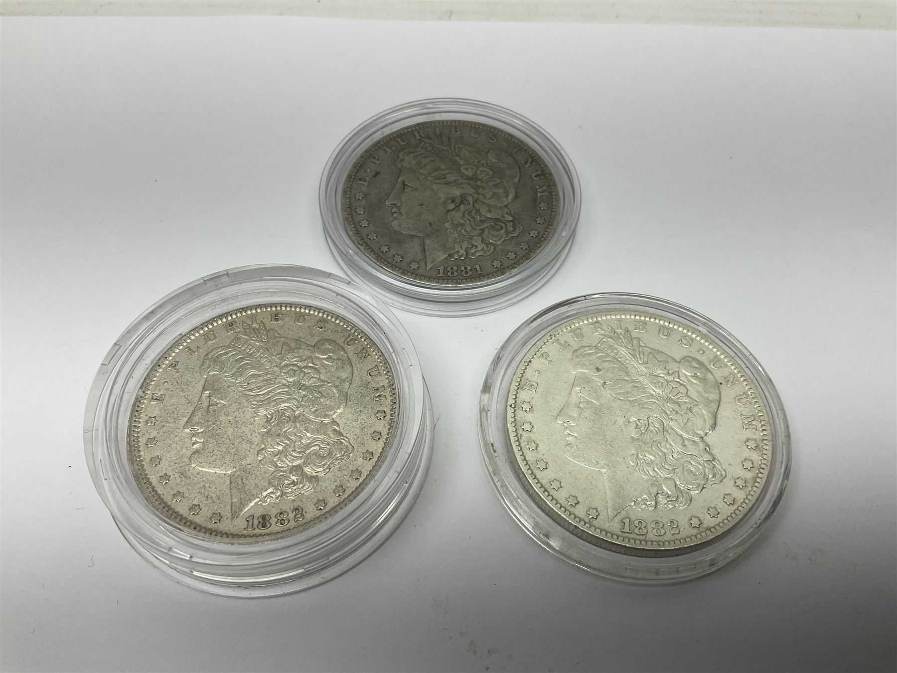 Three United States of America silver Morgan dollar coins dated 1881 O, 1882 and 1882 O