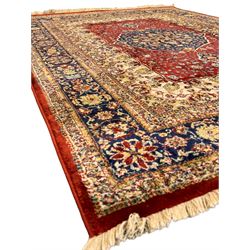 Persian design crimson ground rug, rectangular field with indigo medallion surrounded by trailing and interlaced branches, within wide borders decorated with repeating plant motifs