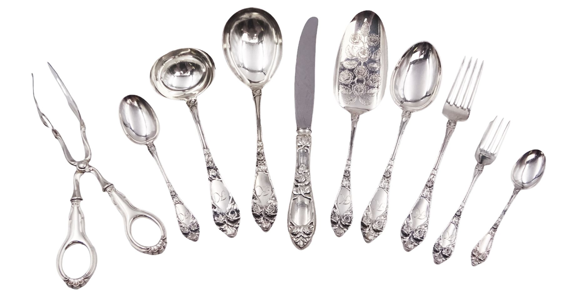 1930s Norwegian silver cutlery for six place settings, comprising table spoons, table forks and silver handled table knives, cake forks, tea spoons and demitasse spoons, one cake slice, serving spoon, sauce ladle and a pair of silver handled servers, all embossed with rose decoration and engraved with initial K to terminal and 10/9 1932 verso, stamped NM 830s