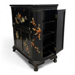 Early 20th century Chinoiserie lacquered cabinet, rounded rectangular top above a fall front enclosing fitted interior with lacquered decoration, over a pair of cupboard doors and flanked by side compartments with tiered bottle shelves, the black lacquer ground decorated throughout with raised and painted floral sprays, on shaped bracket feet