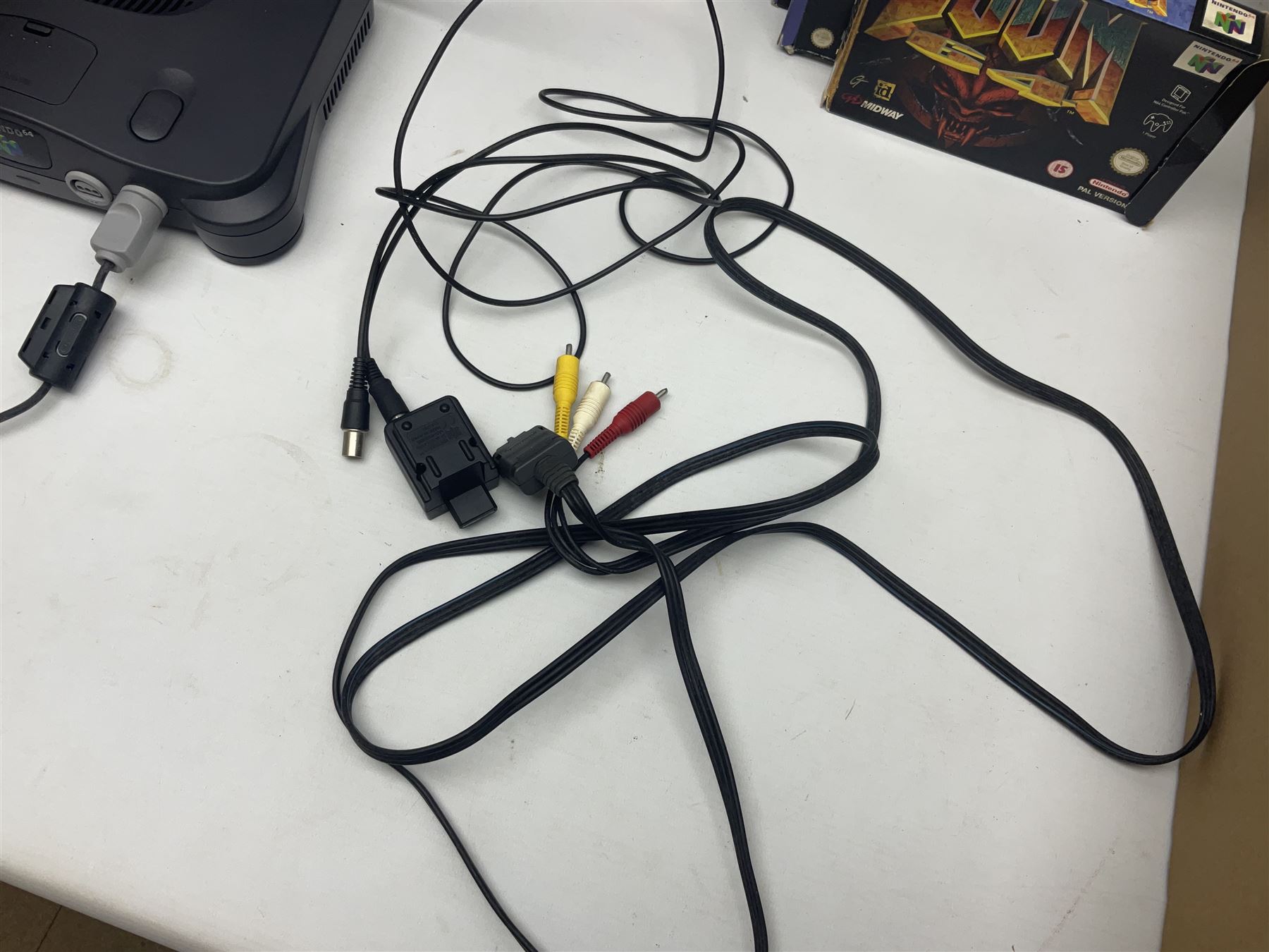 Nintendo 64 console, two controllers, games and accessories. Accessories to include the ‘Tremorpak’ and ‘Spook’ 2 Phono plugs and a S-VHS plug with adapter, both in original boxes. Games to include ‘Golden Eye 007’, ‘Doom 64’, ‘Killer Instinct Gold’, ‘Tetrisphere’, ‘F-1 World Grand Prix’, ‘Pilotwings 64’ and ‘Lylatwars’ with ‘Rumble Pak’, all with original boxes and instruction manuals. ‘Star Wars Episode I Racer’ game cartridge in Shadows of the Empire box. 